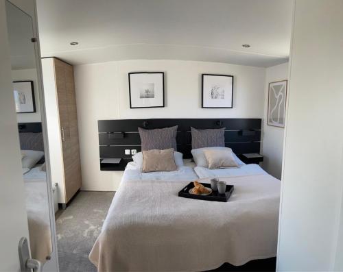 a bedroom with a large bed with a tray of food on it at Dammhuis Zeeland in Oostkapelle