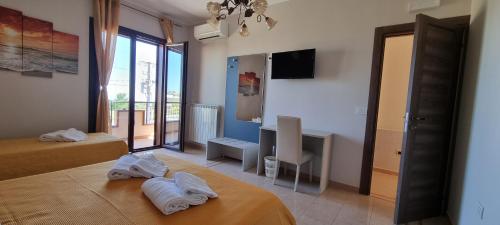 a hotel room with two beds and a television at B&B Villa Eleonora Tropea in Le Pioppe