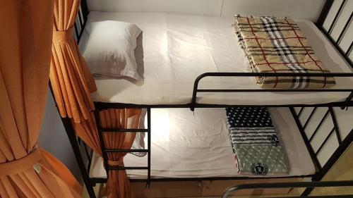 a bunk bed in a room with a ladder at Sky House Hostel in Ho Chi Minh City