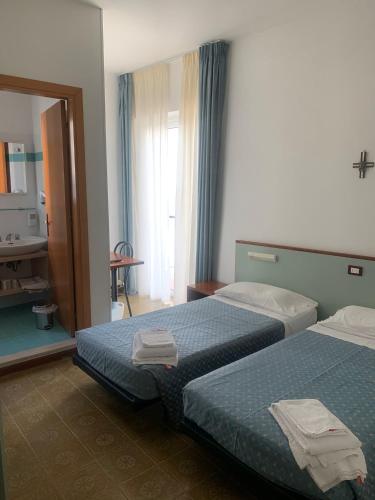 a hotel room with two beds and a bathroom at Hotel Capri in San Benedetto del Tronto