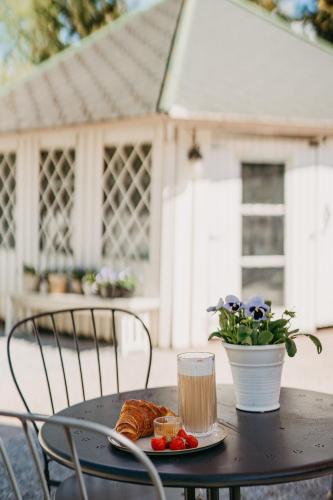a black table with a plate of food and a drink at Lillan Hotel & Kök in Tampere