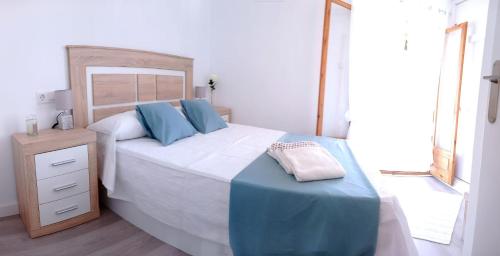 a bedroom with a large bed with blue pillows at Bungalow los Majuelos in Gran Alacant