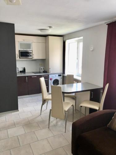 a kitchen and living room with a table and chairs at Smart Stay Apartment in Valmiera