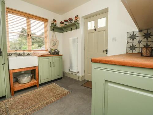 eine Küche mit grünen Schränken und einem Waschbecken in der Unterkunft Norden House in Dorchester