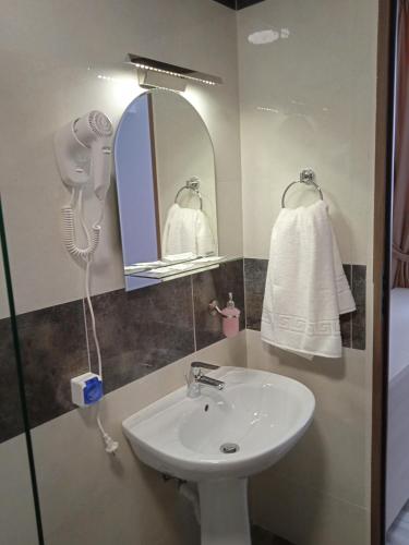 a bathroom with a sink and a mirror and a towel at Hotel Marina srl in Bucharest