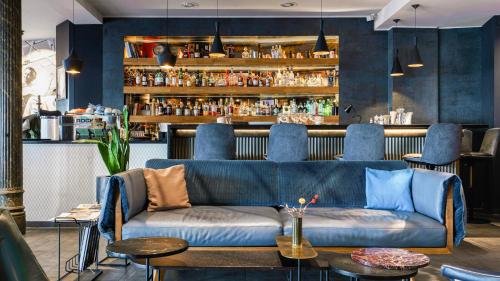 a living room with a blue couch and a bar at The Circus Hotel in Berlin