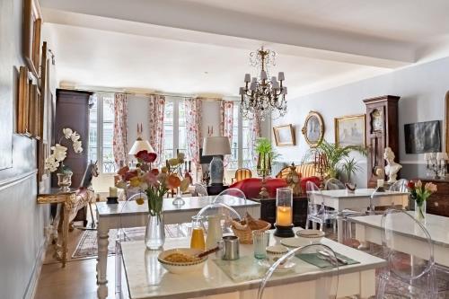 a living room filled with furniture and a chandelier at Hôtel des Arceaux in Bayonne