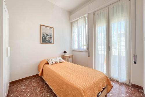 a bedroom with a bed in a room with windows at Il Mare In Giardino in Scauri