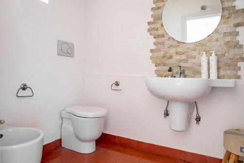 bagno con lavandino, servizi igienici e specchio di Loft Sole by Wonderful Italy a Giarre
