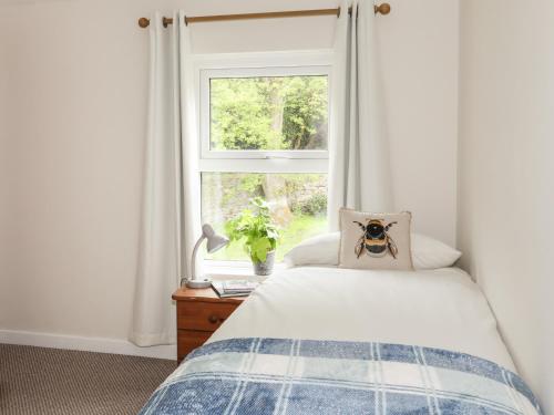 a bedroom with a bed and a window at Lleyn Cottage The Hive in Menai Bridge