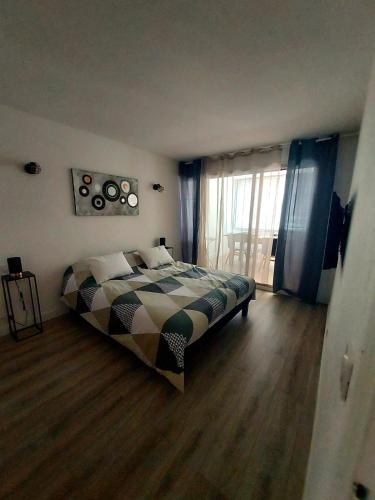 une chambre avec un lit et une grande fenêtre dans l'établissement Appartement T3 plein centre ville, au Lavandou