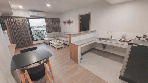 a kitchen and living room with a table and a sink at Nakara Hotel, Ubon Ratchathani in Ban Na Kham