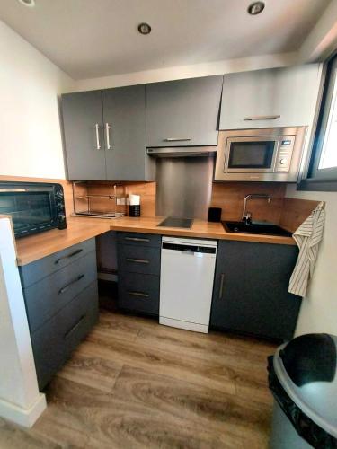 Il comprend une cuisine avec des appareils en acier inoxydable et du parquet. dans l'établissement Appartement T3 plein centre ville, au Lavandou