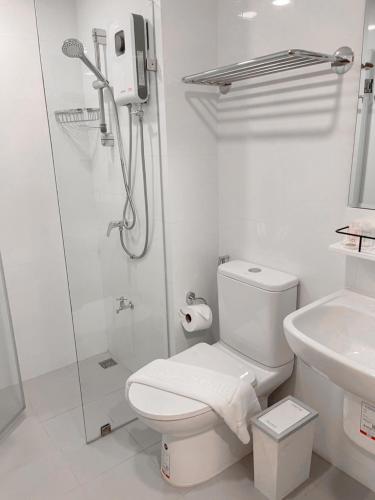 a white bathroom with a shower and a toilet at Nakara Hotel, Ubon Ratchathani in Ban Na Kham
