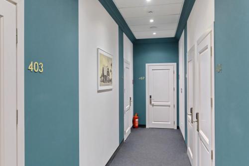 a hallway with blue walls and white doors at Voyage in Odesa