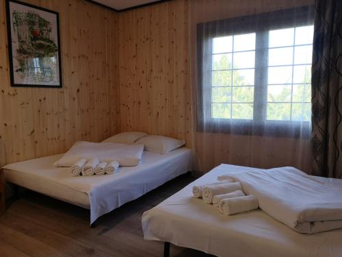 two beds in a room with a window at Marina Park in Vama Veche