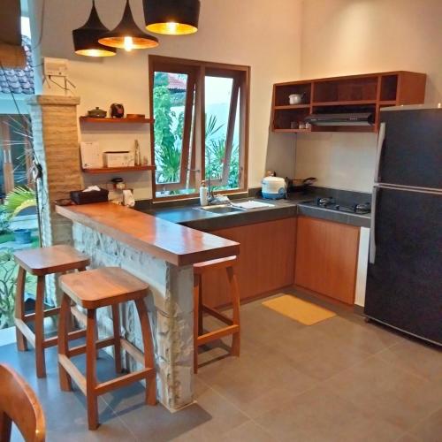 a kitchen with a table and a refrigerator at 3 Orchid in Sanur