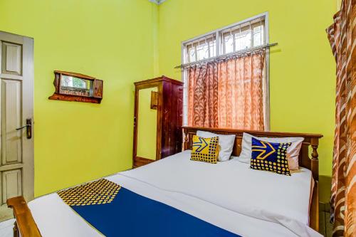 sypialnia z łóżkiem i oknem w obiekcie OYO Homes 91124 Desa Wisata Kaso 