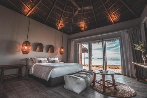 ein Schlafzimmer mit Bett und Blick auf das Meer in der Unterkunft The Mak Trat in Ko Mak