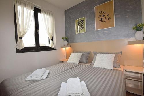 a bedroom with a large bed with two white chairs at Sole Pula Apartman-near beach in Pula