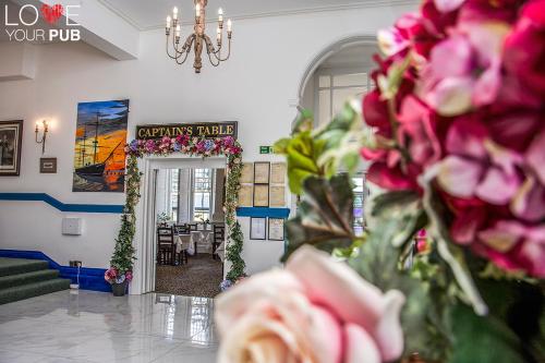 a room with a doorway with flowers and a chandelier at Keppels Head Hotel in Portsmouth