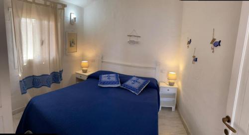 a bedroom with a blue bed with two blue pillows at Bados affaccio sul mare in Olbia