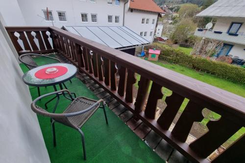a balcony with a table and chairs on a green floor at Haus Kraus in Bayerisch Eisenstein