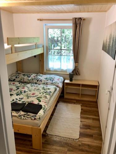 a small bedroom with a bunk bed and a window at Chata Třeboňsko - rybník Dvořiště - Smržov in Smržov