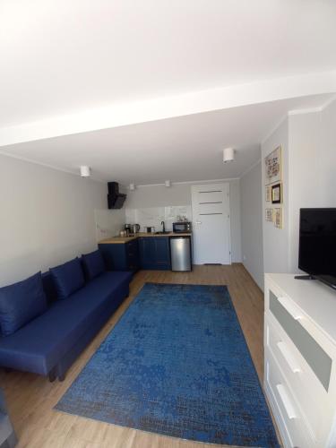 a living room with a blue couch and a blue rug at Orzechowa Przystań in Ustka