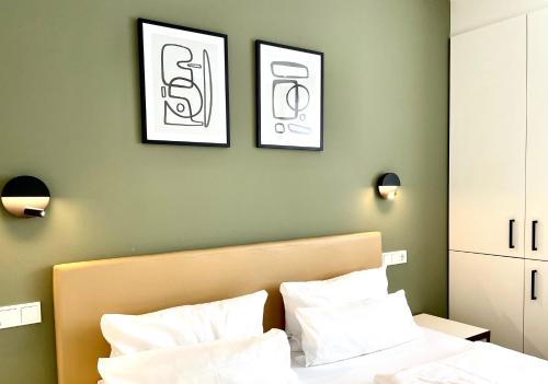 a bedroom with a bed with two pictures on the wall at zeitwohnhaus SUITE-HOTEL & SERVICED APARTMENTS in Erlangen