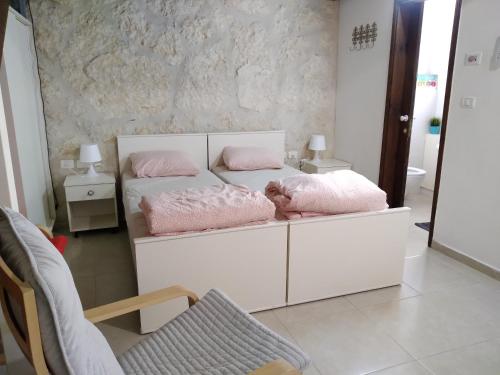 sypialnia z 2 łóżkami i różowymi poduszkami w obiekcie Dead sea families unit w mieście Ovnat