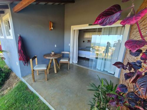 a patio with a table and chairs and a bed at Pousada Terraço Guarapari in Guarapari