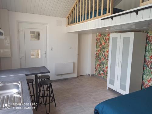 eine Küche mit einer Theke und Hockern in einem Zimmer in der Unterkunft Maisonnette indépendante 4 personnes jardin terrasse in Vrigne-aux-Bois