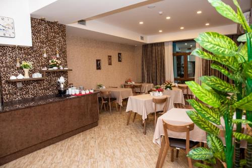 un restaurante con mesas, sillas y plantas en Sebail Inn Hotel, en Baku