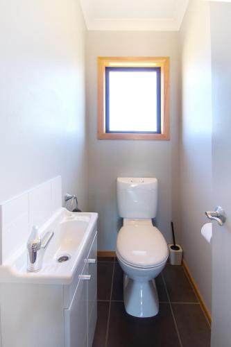a bathroom with a toilet and a sink and a window at Parkview Apartments in National Park