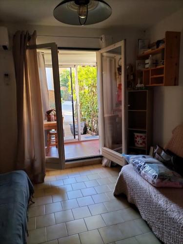 - un salon avec une porte s'ouvrant sur une terrasse dans l'établissement Studio cabine climatisé rez de jardin plage 150m Boucanet, au Grau-du-Roi