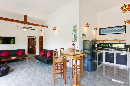 a kitchen and living room with a table and chairs at 2 Bays Villa in Thong Nai Pan Yai