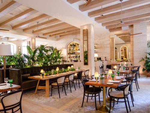 een restaurant met houten tafels, stoelen en planten bij Browns Avenue Hotel in Lissabon