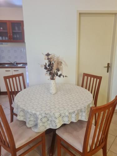 a dining room table with a vase of flowers on it at HOUSE LALA in Vinišće