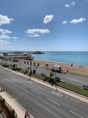 an empty road next to a beach with the ocean at Stunning Beachfront Apartment, Perfect Sea View. in Worthing