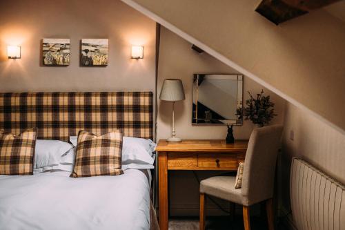 a bedroom with a bed and a desk and a mirror at The Waddington Arms in Waddington