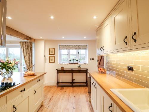 a kitchen with white cabinets and a window at Lake View in Crediton