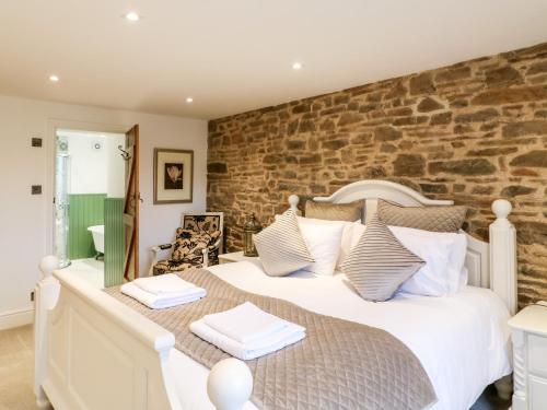 a bedroom with a large bed and a stone wall at Lake View in Crediton