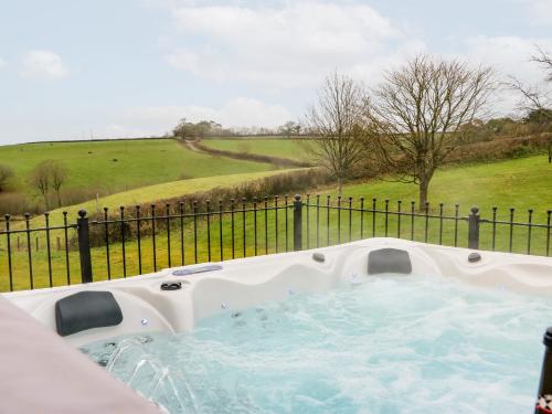 a hot tub in front of a fence at Lake View in Crediton