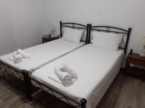 a bedroom with two beds with towels on them at Christen house in Periyiálion