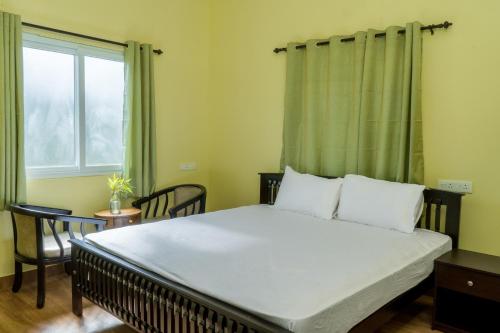 a bedroom with a large bed with a window at Biosphere in Coonoor
