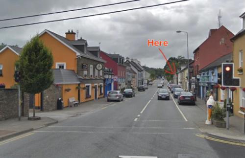 a town street with a sign that says here at Mariners Rest One Bedroom Apartment in Innishannon Village in Cork