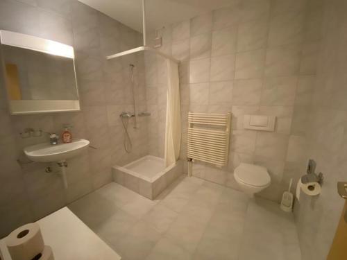 a white bathroom with a toilet and a sink at SKY Rooms, Mountainous View in Saas