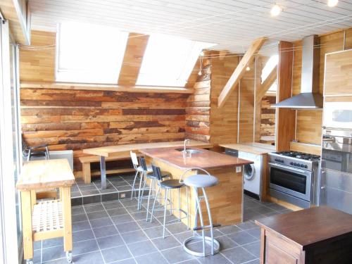 a kitchen with wooden walls and a table and chairs at Maison du Giraldès Claux Puy Mary GR400 gite chalet in Le Claux