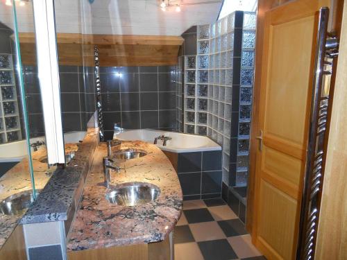a bathroom with a counter with two sinks and a tub at Maison du Giraldès Claux Puy Mary GR400 gite chalet in Le Claux